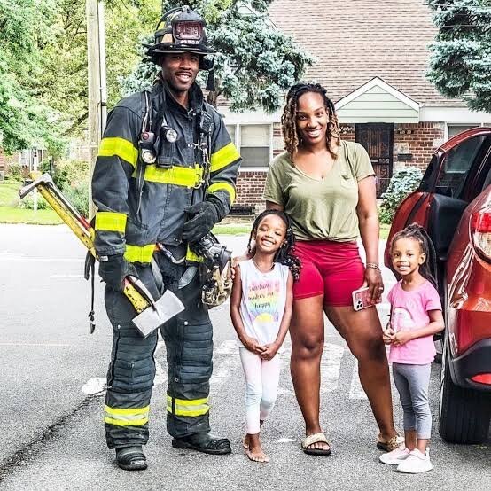 A firefighter with his wife and daughters at home